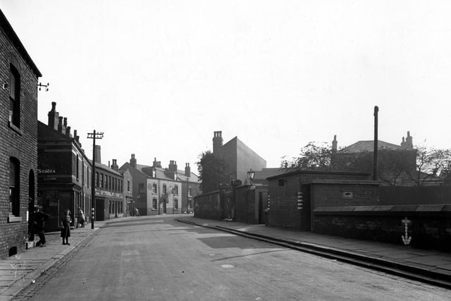 A view looking South along Oak Road in September 1945. 'Brunswick Hotel', 'Geo Stokehill House Furnishers' and shop of 'Elizabeth Nutter' visible. People in street. End of Stapletons Row can be seen.