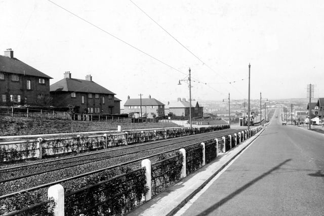 View of Selby Road, Halton Hill area. On the left are semi detached houses on Carden Avenue. Fenced off tramlines can be seen to centre of carriage way. Photo is looking in direction of city centre. Carden Avenue is the entrance to the William Sutton Trust estate, Carden is named after an ex-trustee of the estate. Pictured in September 1938.
