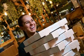 Paige Clarke, Duty Manager of ASK Italian at Xscape Yorkshire with a stack of pizzas