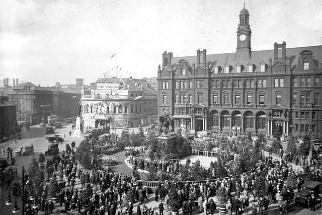 A view looks across City Square towards Wellington Street, the Majestic Cinema and the General Post Office in September 1928. The Square is thronged with people taking part in Civic Week celebrations and has been decorated with lawns, flowers, and small trees. During the week, City Square was host to daily concerts by the Leeds City Police Band.