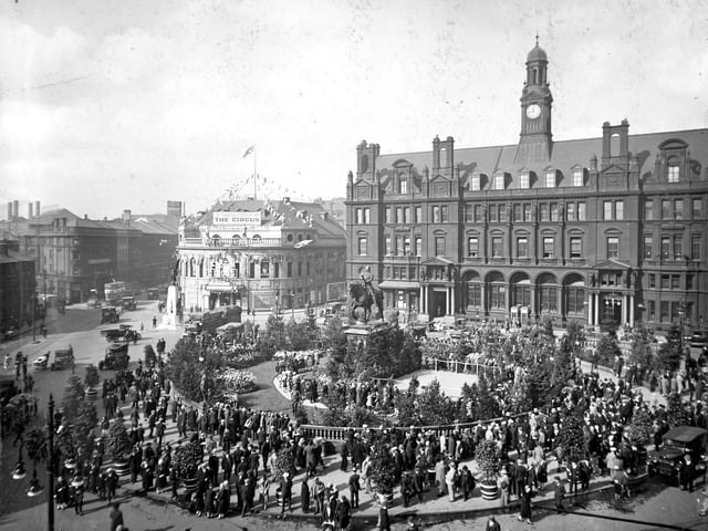 A view looks across City Square towards Wellington Street, the Majestic Cinema and the General Post Office in September 1928. The Square is thronged with people taking part in Civic Week celebrations and has been decorated with lawns, flowers, and small trees. During the week, City Square was host to daily concerts by the Leeds City Police Band.