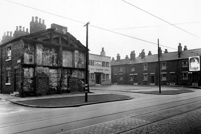 Looking diagonally across Balm Road to the Railway Hotel. The public house has a mural of a steam train above Bentley's Yorkshire Beers written on the modern frontage. To the left, the remains of the demolished last house on the end of Hardwick Place can be seen. Pictured in October 1950.