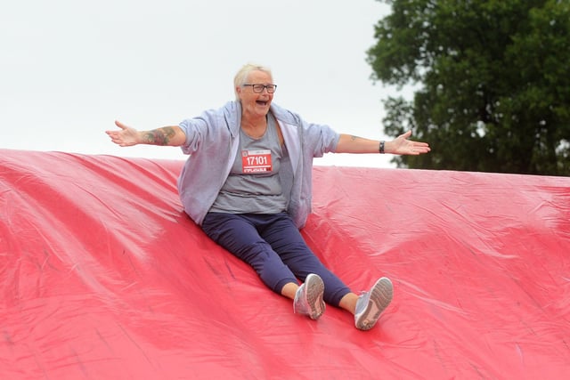 A woman pictured sliding down an inflatable.