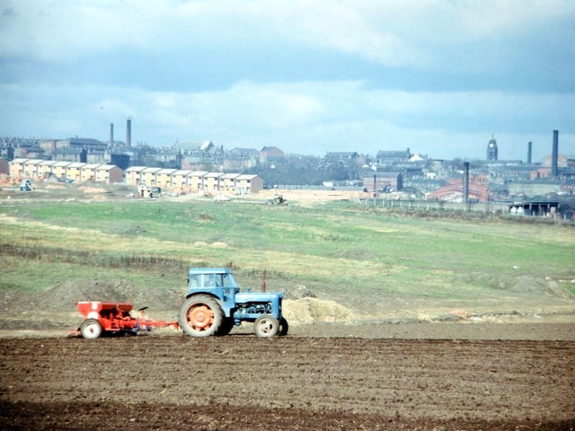 Looking westwards from Topcliffe Lane (beyond Glen Mills) towards Morley town centre. The Town Hall and Peel Mills are visible on the horizon, right. Towards the left of the image, in the middle distance, new council housing on the Glen estate is being constructed. This eventually came to occupy much of the green field land in the centre of the image. Later still, the land in the foreground being prepared for cultivation also succumbed to the housing.