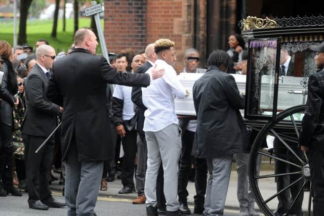 Brother Mallik Wilks helps to carry his older brother's coffin.