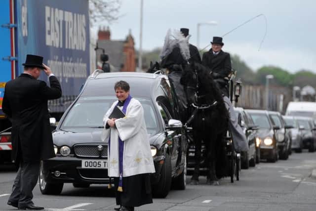 Rev Andi Hofbauer in front of the funeral procession as it arrives at the church.