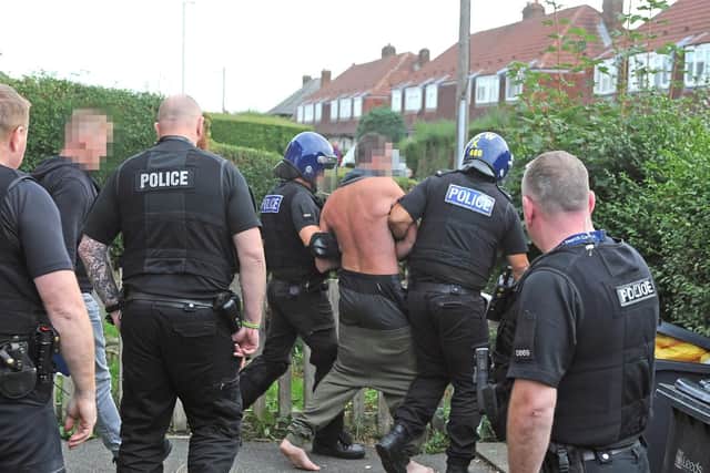 A half-dressed suspect is led away by police.