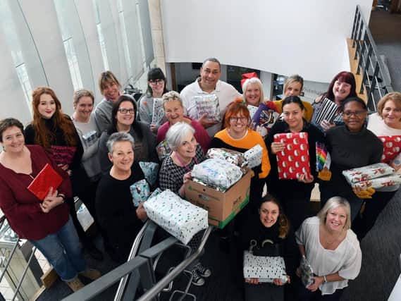 Staff and volunteers who are putting on a Christmas dinner for care leavers, wrapping donated presents ready for the day.