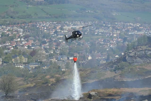 Firefighters use a helicopter to drop water as they tackle a large fire which is continuing to burn on Ilkley Moor in West Yorkshire. Danny Lawson/PA Wire