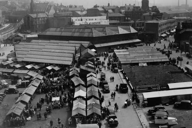 Dewsbury open air market with the station and town hall in the background.
