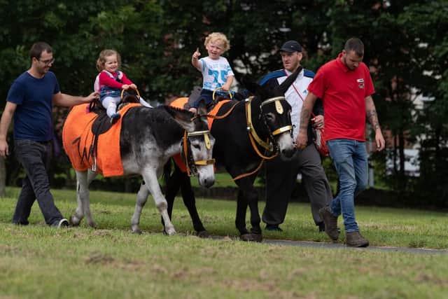 Enjoying the donkey ride were Jason Crossley, holding his daughter Isabelle, two, and Kyle Carpenter, holding his son Stephen, four. Picture: James Hardisty.