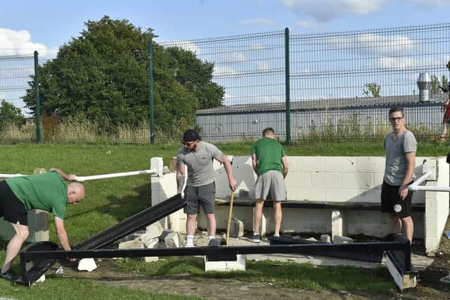 Beeston St Anthony's players dismantle the vandalised dug outs (Photo and video: Steve Riding)