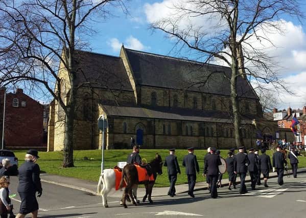 CASH BOOST: People gather outside St Lukes Church in Holbeck to mark Palm Sunday.