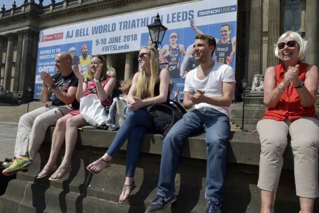 Spectators cheer on the elite women's race competitors outside Leeds Town Hall.