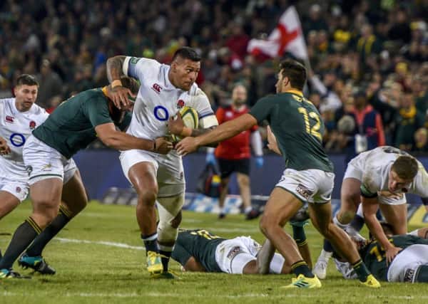 South Africa's Thomas du Toit, left, tackles England's Nathan Hughes in the second rugby test match between South Africa and England in Bloemfontein. Picture: AP/Christiaan Kotze.