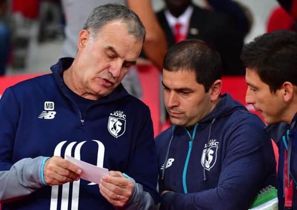 Marcelo Bielsa talks to backroom staff Pablo Quiroga and Diego Reyes during his time at Lille.