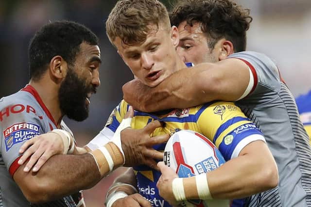 Leeds Rhinos' Ash Handley is tackled by Catalans Dragons' Samisoni Langi (left) and Louis Anderson (right), during the Betfred Super League match at Emerald Headingley. PIC: Martin Rickett/PA Wire