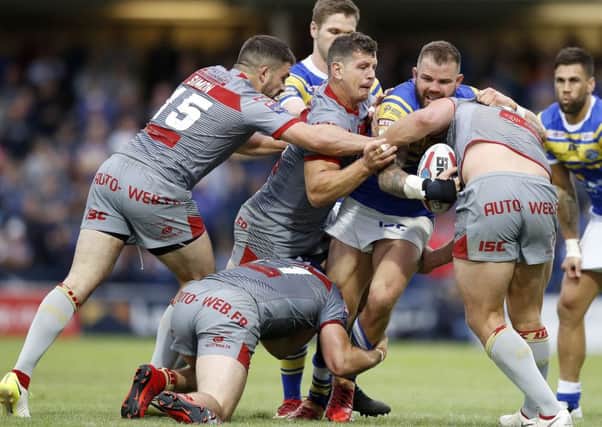 Leeds Rhinos' Adam Cuthbertson hits a wall of Catalans Dragons defenders. PIC: Martin Rickett/PA Wire