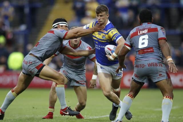 Willing worker Ash Handley is tackled by Catalans Dragons' David Mead (left) and Samisoni Langi (right). PIC: Martin Rickett/PA Wire