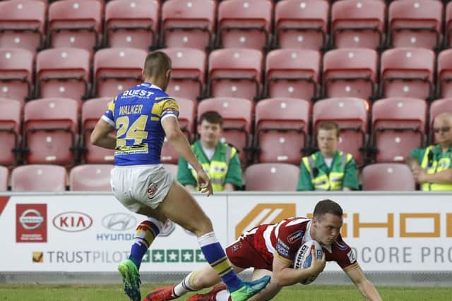 Wigan Warriors' Liam Marshall goes over for a try past Leeds Rhinos' Jack Walker.
