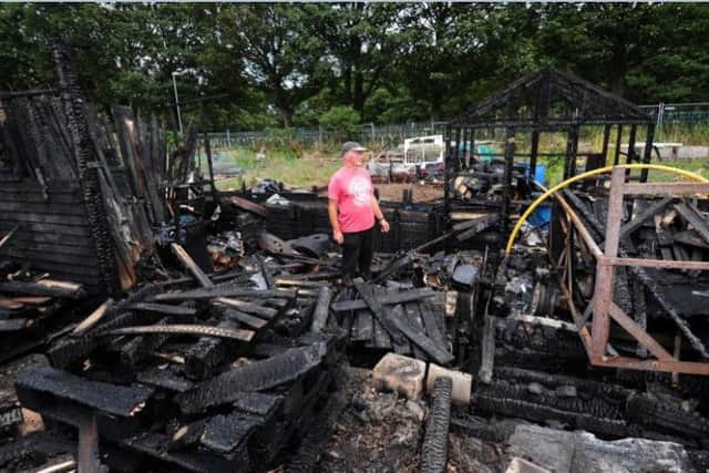 Peter Liversidge stands among the blackened remains of the wooden structures destroyed in the fire. Photos: Simon Hulme.
