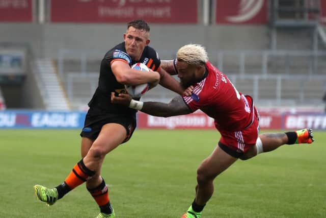 Castleford Tiger's Greg Eden is tackled by Salford Red Devils' Junior Sa'u during. Picture: Martin Rickett/PA