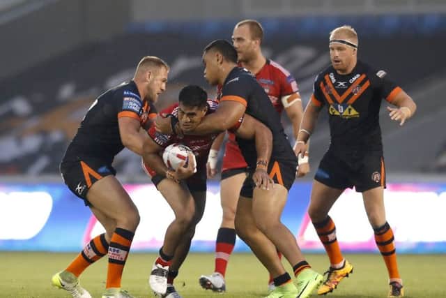 Salford Red Devils' Lama Tasi (centre left) is tackled by Castleford Tigers' Oliver Holmes (left) and Junior Moors. Picture: Martin Rickett/PA