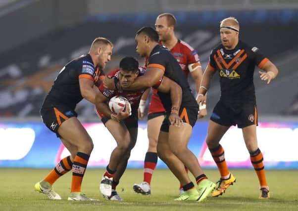Salford Red Devils' Lama Tasi (centre left) is tackled by Castleford Tigers' Oliver Holmes (left) and Junior Moors. Picture: Martin Rickett/PA