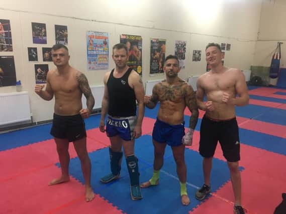 Founder and chief instructor Richard Smith, centre left,with some of the fighters at Bad Company Thai Boxing Gym.