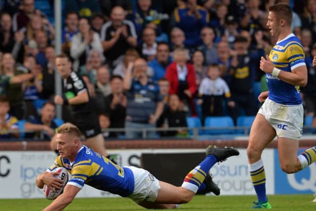 Brad Dwyer slides over for the Rhinos opening try against Widnes.