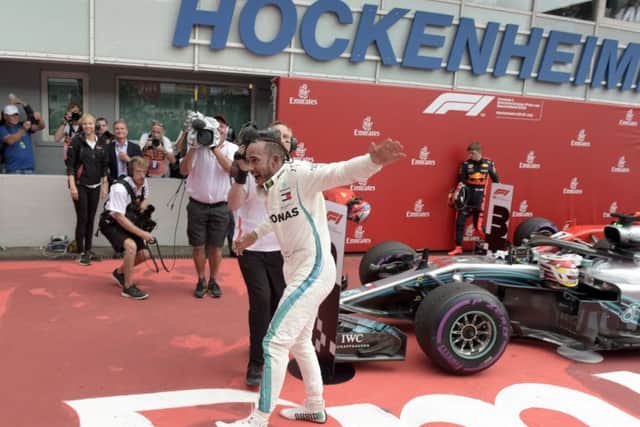 CATCH ME IF YOU CAN: Lewis Hamilton celebrates after winning the German Formula One Grand Prix at the Hockenheimring racetrack in Hockenheim. Picture: AP/Jens Meyer