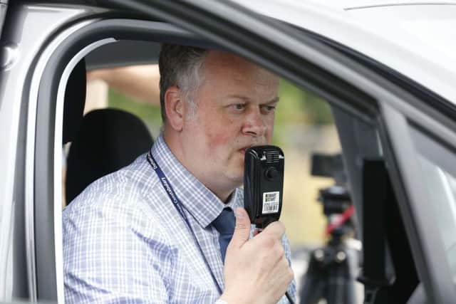 DI Andy Crowe demonstrates a new device which stops drink drivers from starting their engine if they are over the legal drink drive limit. PIC: PA