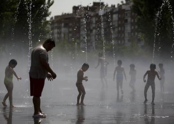 People cool off in an urban beach at Madrid Rio park in Madrid.  PIC: AP