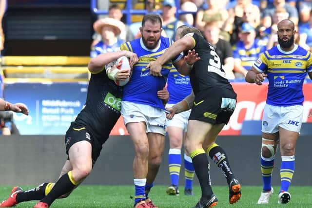 Leeds Rhinos' Adam Cuthbertson is tackled by the Warrington defence.