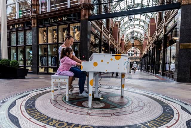 Date: 17th August 2018. Picture James Hardisty. Leeds International Piano Festival is launching a piano trail around Leeds, with funky decorated pianos popping up at locations all over the city for people to play. Pictured Playing a piano in the Victoria Quater, Leeds, Kirsten Freeman, of Leeds, alongside her Granddaughter Fifi Costigan, aged 3.