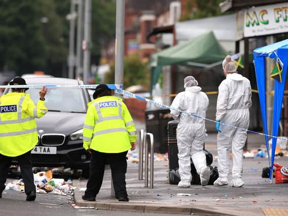Police at the scene of the shooting in Moss Side, Manchester. Photo: PA