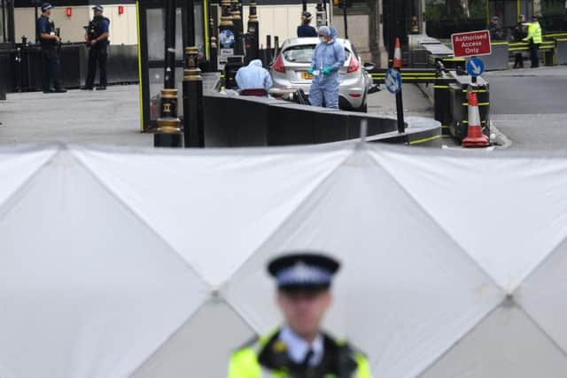 Forensic officers by the car that crashed into security barriers outside the Houses of Parliament, Westminster, London. PIC: Stefan Rousseau/PA Wire