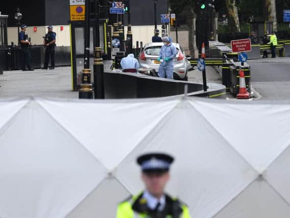 Forensic officers by the car that crashed into security barriers outside the Houses of Parliament, Westminster, London. PIC: Stefan Rousseau/PA Wire