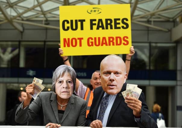 Protesters dress up as Prime Minister Theresa May and Transport Secretary Chris Grayling during a protest at rising rail fares.