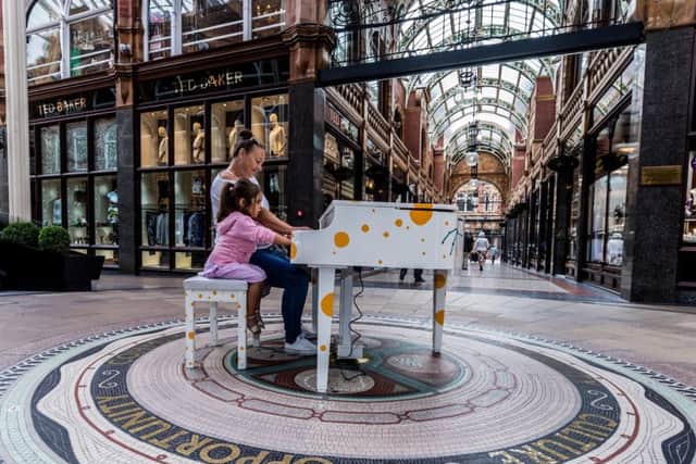 Playing a piano in the Victoria Quarter, Leeds, Kirsten Freeman, of Leeds, alongside her Granddaughter Fifi Costigan, aged 3.