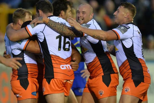 Castleford's Junior Moors celebrates with team-mates after scoring against Warrington.