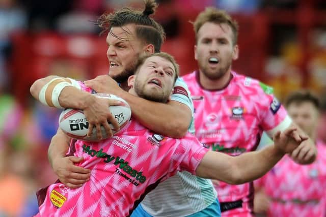 Bulldogs' Brad Day is caught by a high tackle from  Kyle Trout, of Dewsbury Rams. PIC: Tony Johnson