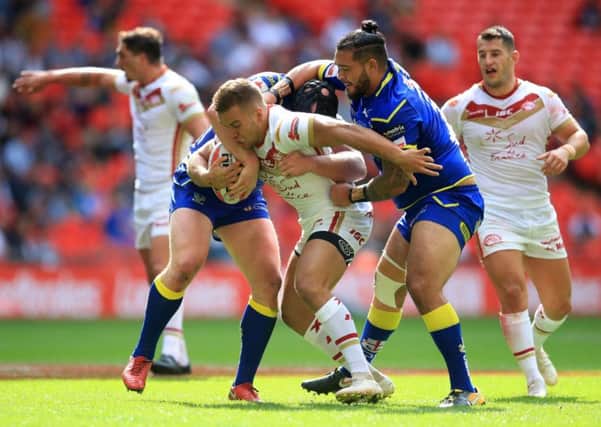 Cataland Dragons' Mickael Goudemand is tackled by Warrington Wolves' Ben Murdoch-Masila during the Ladbrokes Challenge Cup Final.