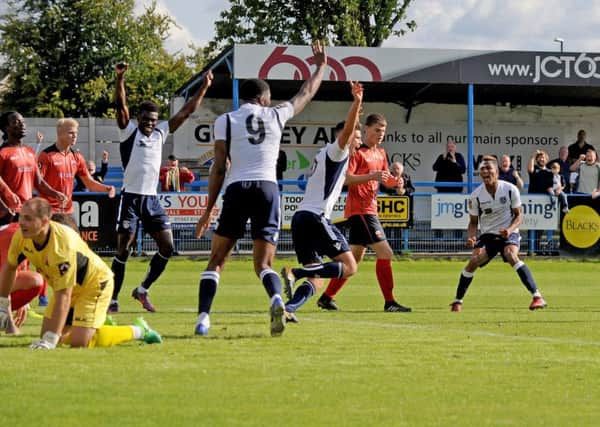 Kaine Felix, right, of  Guiseley scores the added time winner against Nuneaton. Picture: Steve Riding.