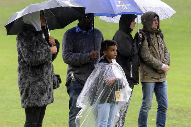 Umbrellas out for the downpour at Potternewton Park.
