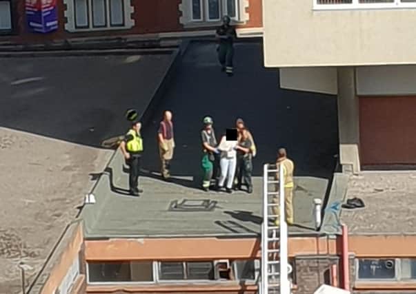 The woman is led away from the roof (pic by Alex Tilson)