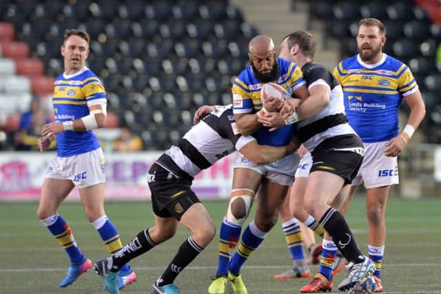 Jamie Jones-Buchanan is held by Lloyd White and Greg Burke in this year's Challenge Cup clash at Halton Stadium. Picture: Bruce Rollinson