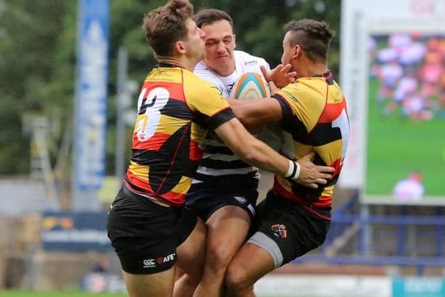 Pete Lucock of Yorkshire Carnegie is caught in a double tackle.