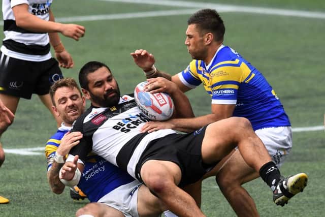 Richie Myler and Joel Moon tackle Widnes' Patrick Ah Van.
