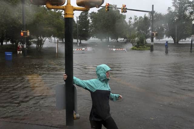 Jamie Thompson walks through flooded sections of East Front Street near Union Point Park in New Bern, North Carolina.